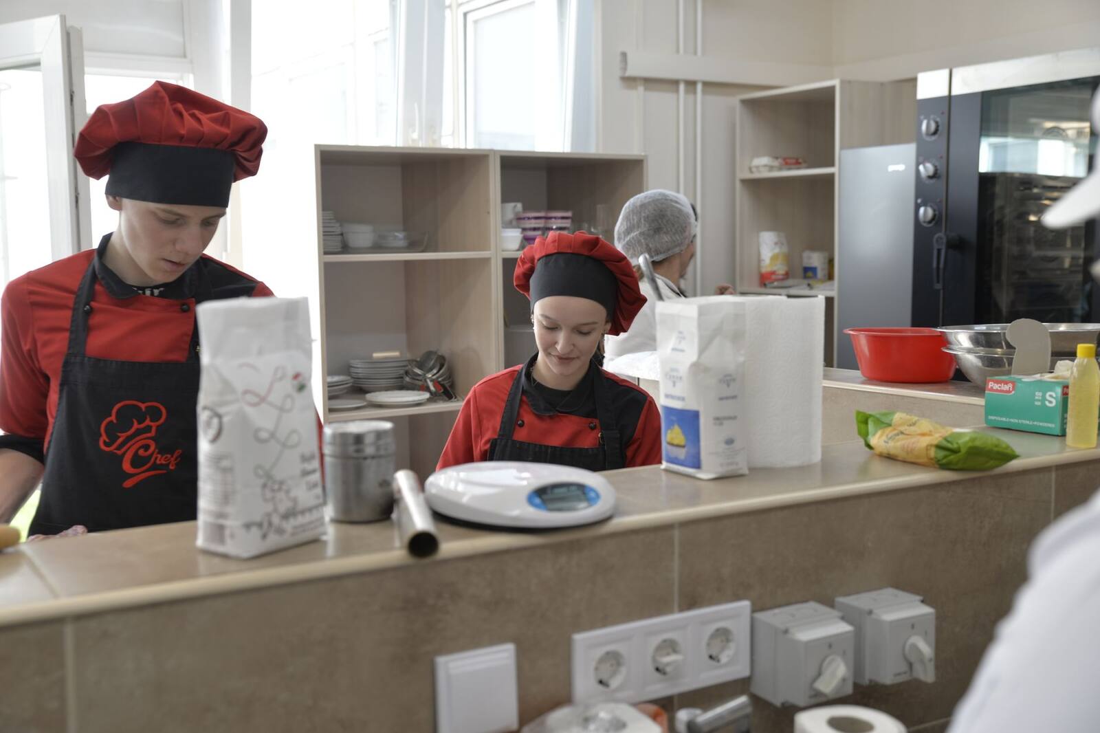 Chef preparing food in a busy restaurant kitchen